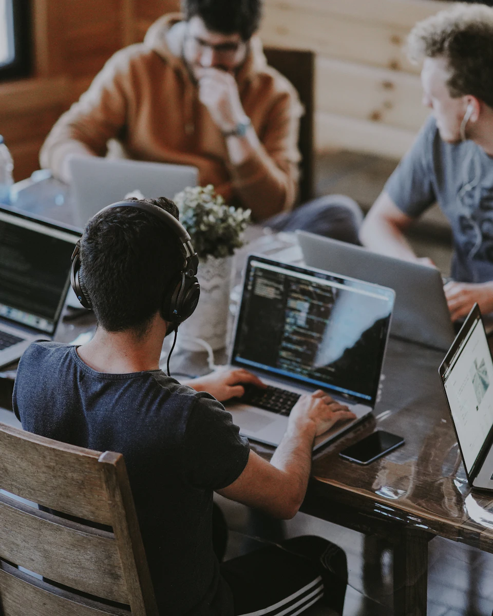 Software team collaborating around a laptop in an office